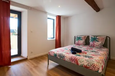 a bedroom with a bed and a window at Le Rempart Harmonieux - Triplex au pied de la Cité in Carcassonne