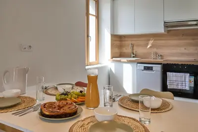a kitchen with a table with a cake on it at Le Rempart Harmonieux - Triplex au pied de la Cité in Carcassonne