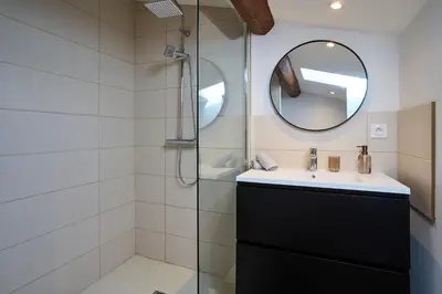 a bathroom with a shower and a sink and a mirror at Le Rempart Harmonieux - Triplex au pied de la Cité in Carcassonne