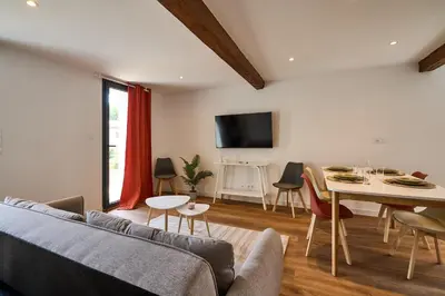 a living room with a couch and a table at Le Rempart Harmonieux - Triplex au pied de la Cité in Carcassonne