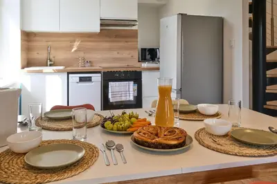a table with plates of food on it in a kitchen at Le Rempart Harmonieux - Triplex au pied de la Cité in Carcassonne