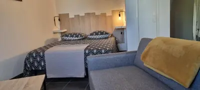 a small room with a bed and a couch at Jardin des oiseaux in Narbonne