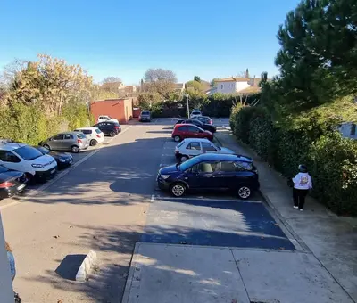 a group of cars parked in a parking lot at Jardin des oiseaux in Narbonne