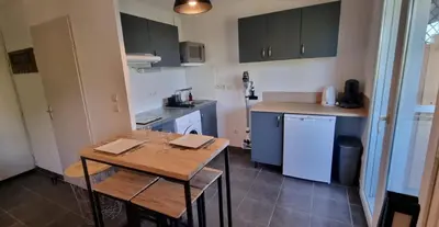 a small kitchen with a wooden table in a room at Jardin des oiseaux in Narbonne