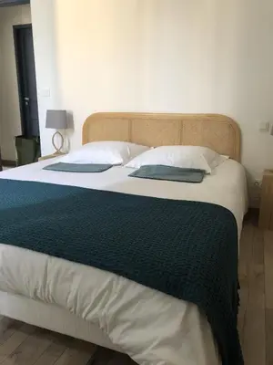 a large bed with a black and white blanket on it at Maison Corbieres in Peyriac-de-Mer