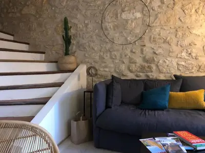 a living room with a blue couch and stairs at Maison Corbieres in Peyriac-de-Mer