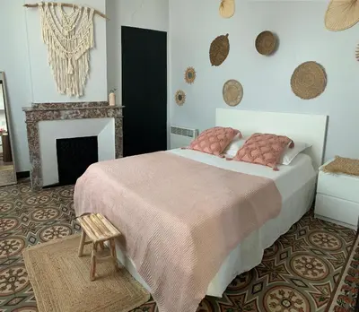 a bedroom with a large bed and a fireplace at La maison de la gare in Carcassonne
