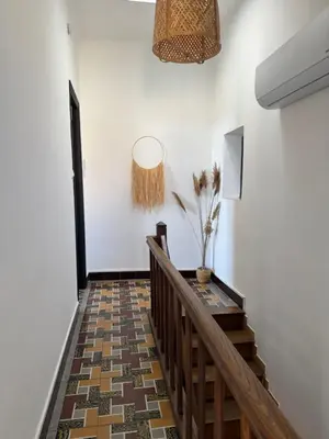 a hallway with a staircase with a potted plant on the wall at La maison de la gare in Carcassonne