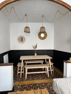 a dining room with a table and a bench at La maison de la gare in Carcassonne