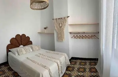 a white bedroom with a bed and a rug at La maison de la gare in Carcassonne