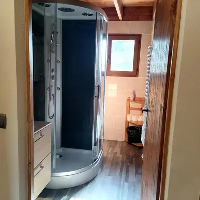 a bathroom with a shower with a glass door at Chalet 