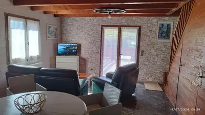 a living room with couches and a table and a tv at Chalet 