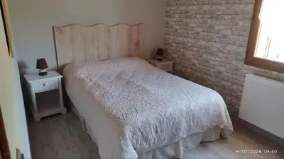 a bedroom with a white bed and a brick wall at Chalet 