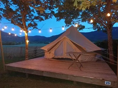 a tent sitting on a wooden deck with lights at Camping du lac Fontclaire in Puivert
