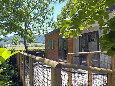 a tiny house with a wooden fence at Camping du lac Fontclaire in Puivert