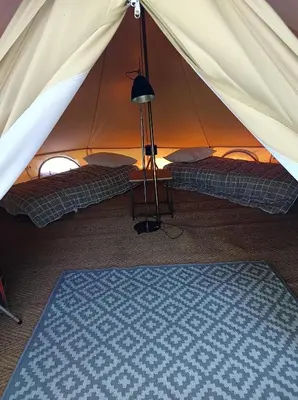 a tent with two beds and a lamp in a room at Camping du lac Fontclaire in Puivert