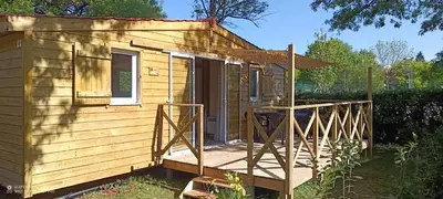 a tiny house with a porch and a deck at Camping du lac Fontclaire in Puivert