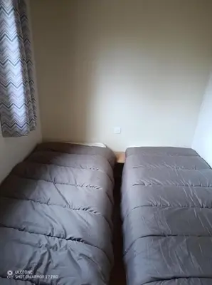 two beds in a room with a window at Camping du lac Fontclaire in Puivert