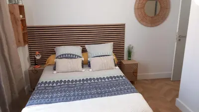 a bedroom with a bed with blue and white pillows at Studio Valliere les halles 15m2 avec clim in Narbonne