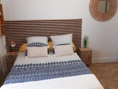 a bedroom with a bed with blue and white pillows at Studio Valliere les halles 15m2 avec clim in Narbonne