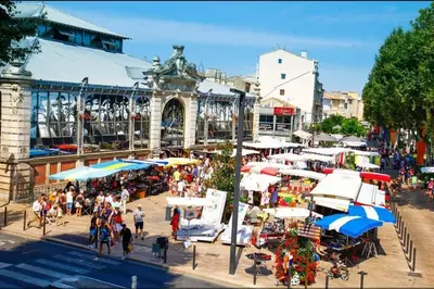 a group of people walking around a market with umbrellas at Studio Valliere les halles 15m2 avec clim in Narbonne