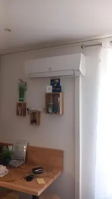 a kitchen with a table and a microwave on the wall at Studio Valliere les halles 15m2 avec clim in Narbonne
