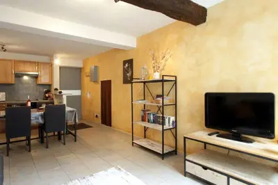 a living room with a television and a dining room at Résidence Armagnac - City Center in Carcassonne
