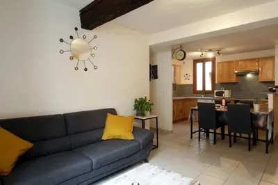 a living room with a couch and a kitchen at Résidence Armagnac - City Center in Carcassonne