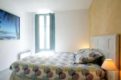 a bedroom with a bed and a lamp and a window at Résidence Armagnac - City Center in Carcassonne