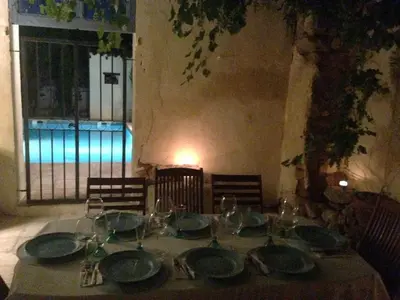a table with green plates and wine glasses on it at Maison Pelissier Bed and Breakfast with swemming pool in Cuxac-dʼAude