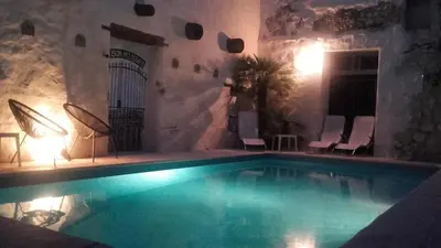 a large swimming pool in a building with chairs at Maison Pelissier Bed and Breakfast with swemming pool in Cuxac-dʼAude