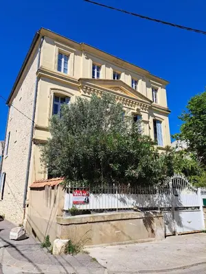 a building with a white fence in front of it at Maison Pelissier Bed and Breakfast with swemming pool in Cuxac-dʼAude