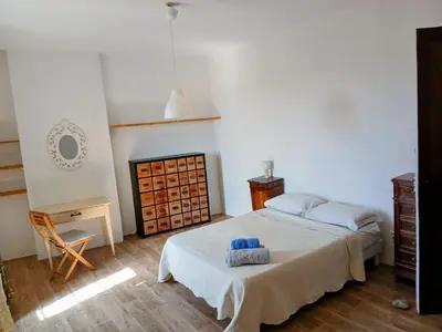 a bedroom with a bed and a table and a chair at Maison Pelissier Bed and Breakfast with swemming pool in Cuxac-dʼAude
