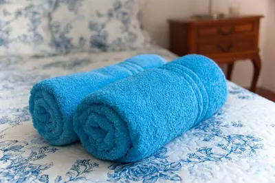 a blue towel is laying on a bed at Maison Pelissier Bed and Breakfast with swemming pool in Cuxac-dʼAude