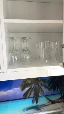 a shelf with several glass glasses on it at Villa familiale climatisée, proche plage & lacs in Port-la-Nouvelle