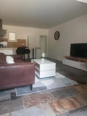 a living room with a couch and a flat screen tv at La Parenthèse in Moussan