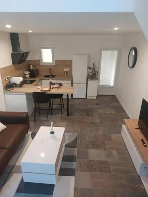 a living room and kitchen with a table and a couch at La Parenthèse in Moussan