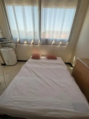 a bed with two pillows in a room with a window at L'Arbousier in Port-la-Nouvelle