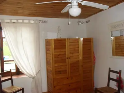 a room with a ceiling fan and a wooden cabinet at Maison Minervoise in Aigne