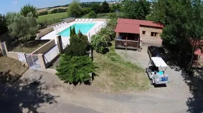 a small white shed with a porch in a yard at Chalet 3 étoiles - Piscine - ccaaaef in Nailloux