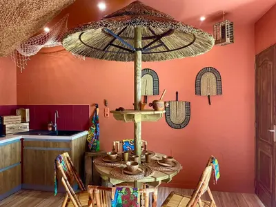 a dining room with a table with an umbrella at Serengeti Safari Room in Sigean