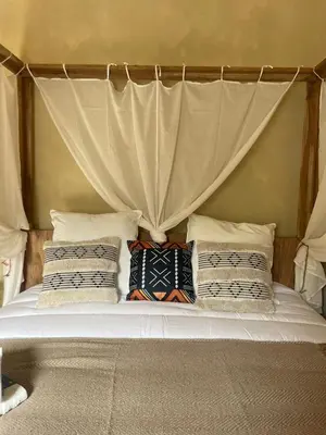 a bed with a canopy with pillows on it at Serengeti Safari Room in Sigean