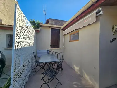 a patio with chairs and a table on the side of a building at La Casa D'Eole YourHostHelper in Narbonne