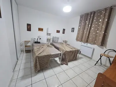 a room with two tables and curtains on the wall at La Casa D'Eole YourHostHelper in Narbonne