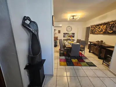 a living room with a table and a large shoe on the wall at La Casa D'Eole YourHostHelper in Narbonne