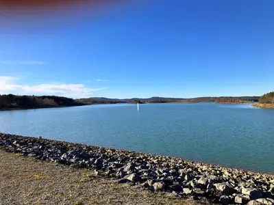 a large group of rocks on the shore of a lake at Maison avec vue sur le Lac de Montbel in Montbel
