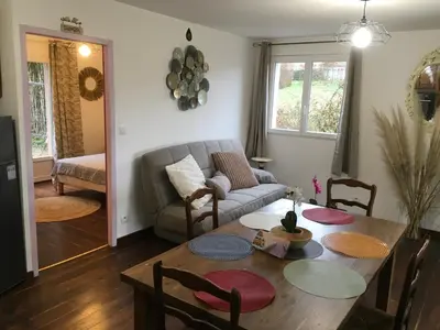 a living room with a table and a couch at Maison avec vue sur le Lac de Montbel in Montbel