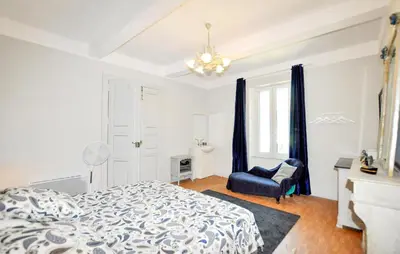 a bedroom with a bed and a blue chair at Gorgeous Home In Thézan-Des-Corbières in Thézan-des-Corbières