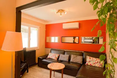 a living room with a leather couch and orange walls at Le Logis d'Aude in Carcassonne