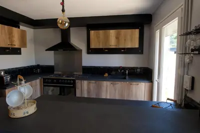 a kitchen with black counter tops and a stove at Le Logis d'Aude in Carcassonne